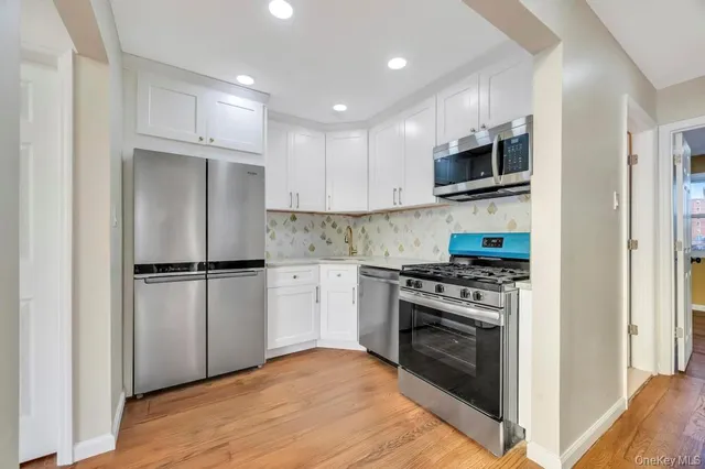 a kitchen with stainless steel appliances a stove sink and microwave