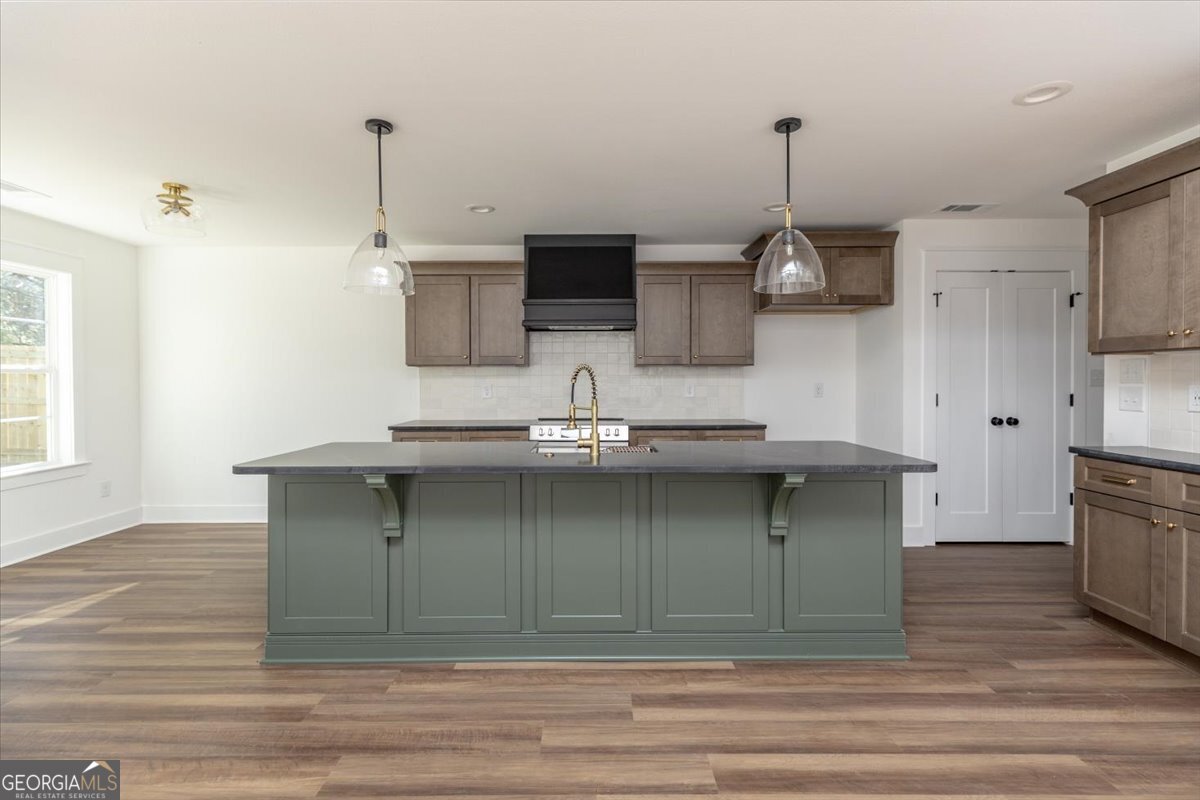 506 New Hope Drive Perry, GA 31069 - Photo 11 of 51 a kitchen with stainless steel appliances granite countertop a sink a stove and a wooden floor