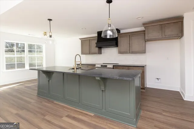 a kitchen with a sink a microwave and wooden floor