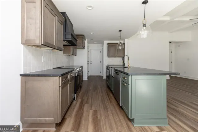a kitchen with stainless steel appliances a stove a sink and a refrigerator