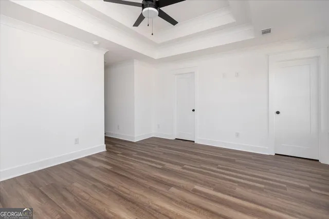 a view of an empty room with wooden floor