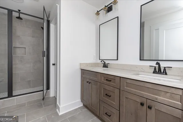 a bathroom with a double vanity sink mirror and shower