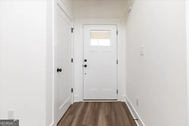 a view of a hallway with wooden floor