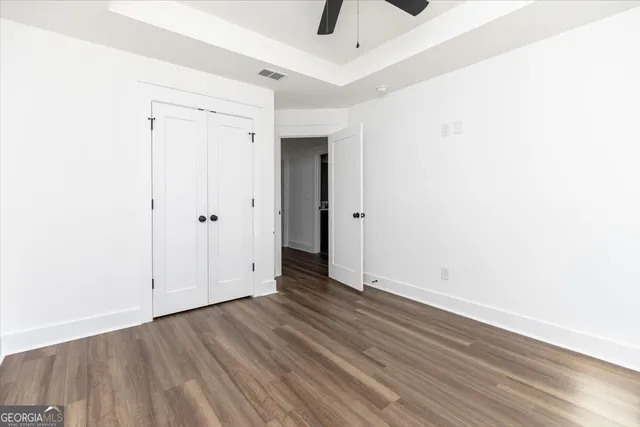 a view of an empty room with wooden floor