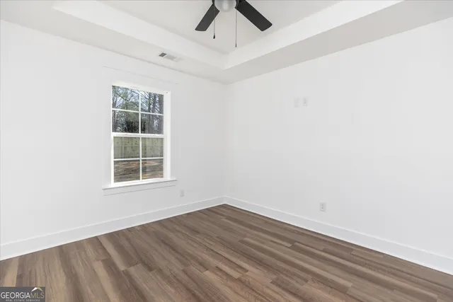 an empty room with a window and a ceiling fan