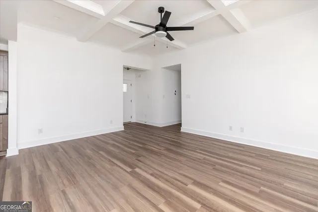 a view of a room with wooden floor and a ceiling fan