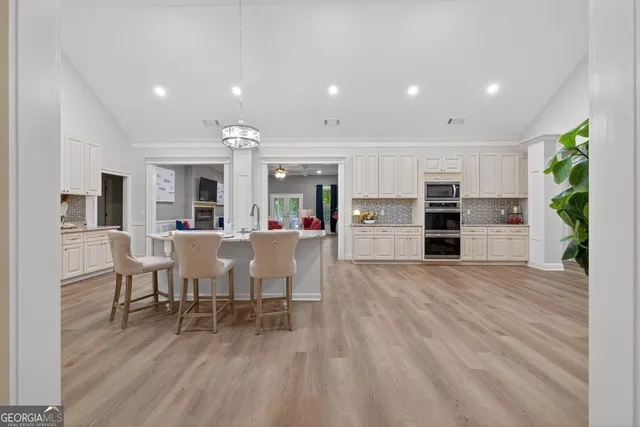 a kitchen with granite countertop white cabinets and stainless steel appliances