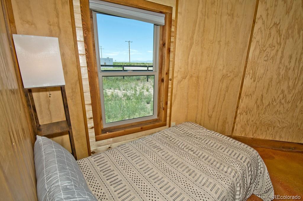 426 Shakedown Street Moffat, CO 81143 - Photo 13 of 17 a bedroom with a bed and a window with wooden floor