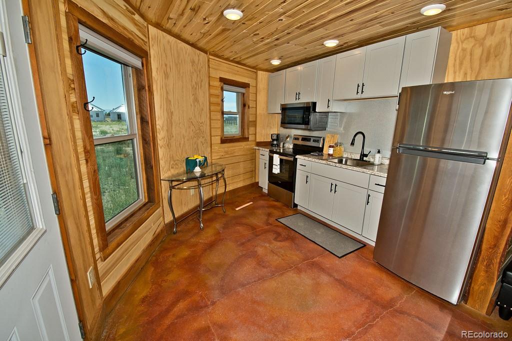426 Shakedown Street Moffat, CO 81143 - Photo 2 of 17 a kitchen with white cabinets and refrigerator