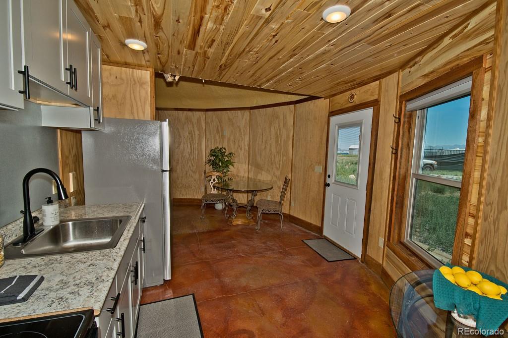 426 Shakedown Street Moffat, CO 81143 - Photo 4 of 17 a kitchen that has a sink a stove and a refrigerator