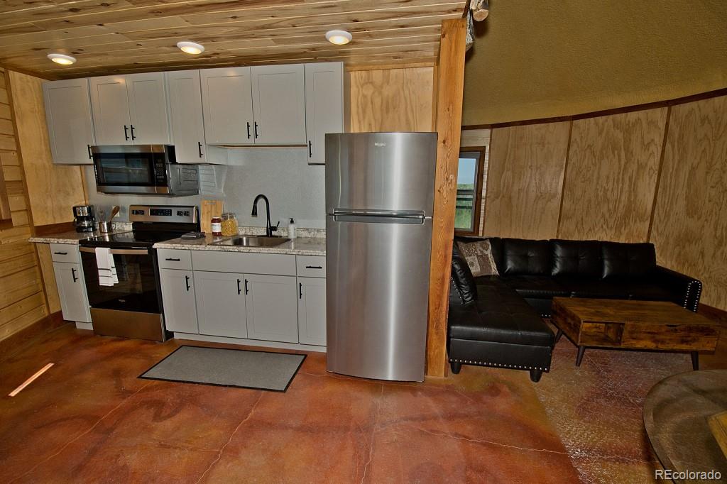 426 Shakedown Street Moffat, CO 81143 - Photo 6 of 17 a kitchen with stainless steel appliances a refrigerator sink and cabinets