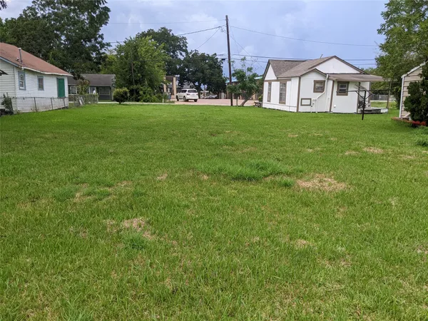 a view of a house with a big yard plants and large trees