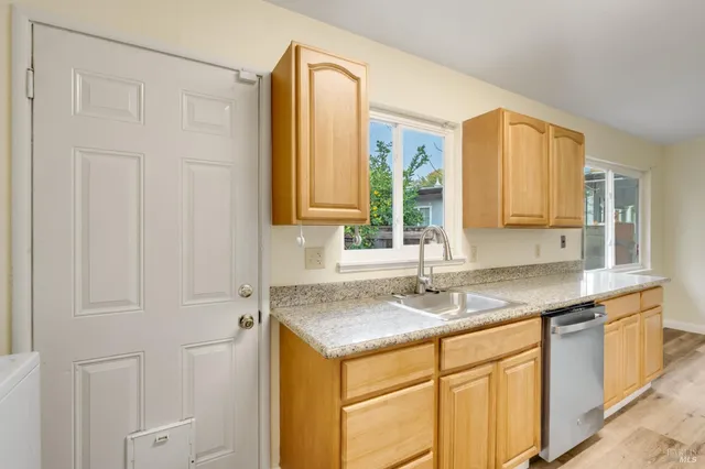a kitchen with stainless steel appliances granite countertop a sink and a granite counter tops with white cabinets