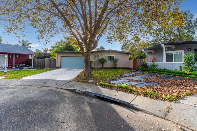front view of a house with a yard and potted plants