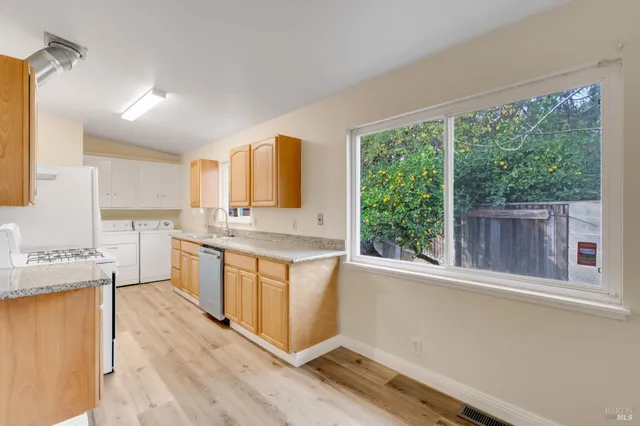 a large kitchen with granite countertop a window a sink and cabinets
