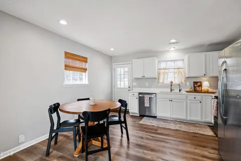 a kitchen with refrigerator cabinets dining table and chairs