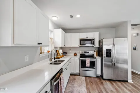 a kitchen with stainless steel appliances a refrigerator a sink a stove a microwave and cabinets