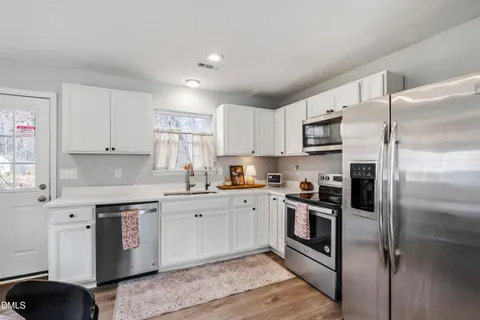 a kitchen with a refrigerator sink and wooden cabinets