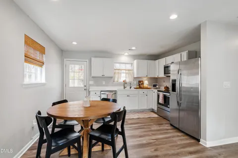a kitchen with refrigerator cabinets dining table and chairs