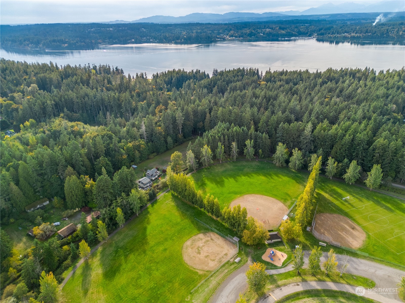-ne Northeast N Tolo Road Bainbridge Island, WA 98110 - Photo 10 of 12 a view of a lake with a yard and large trees