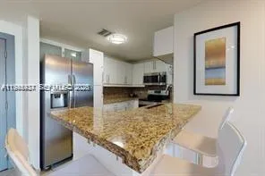 a kitchen with kitchen island granite countertop a sink stove and refrigerator