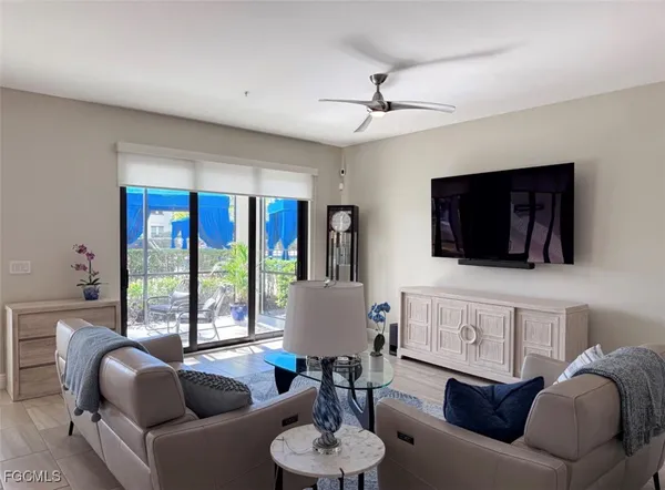 a living room with furniture a flat screen tv and a large window