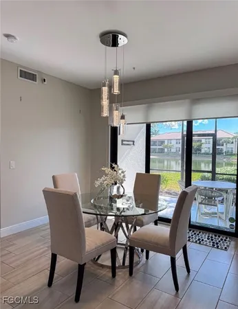 a dining room with furniture a chandelier and wooden floor