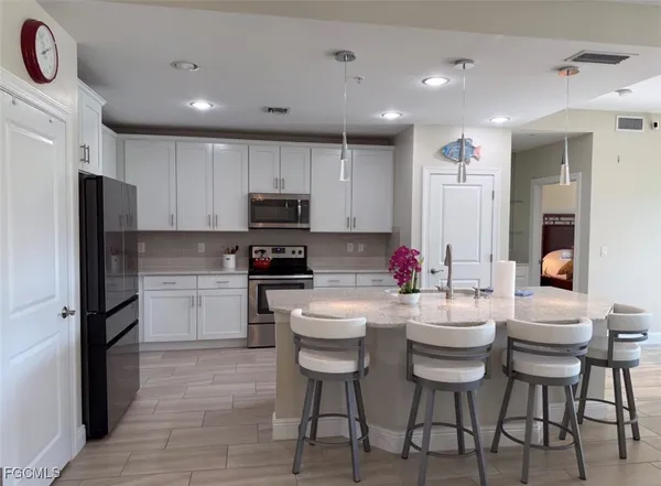a kitchen with white cabinets and stainless steel appliances