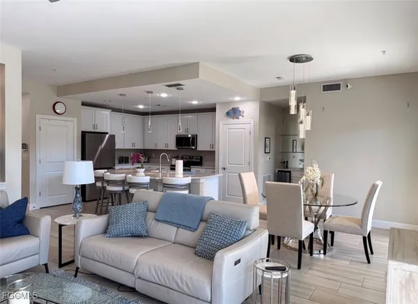 a living room with furniture kitchen view and a dining table