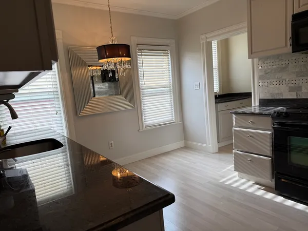 a kitchen with granite countertop stainless steel appliances and wooden floor