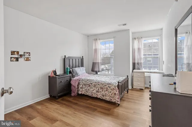 a bedroom with a bed and large windows