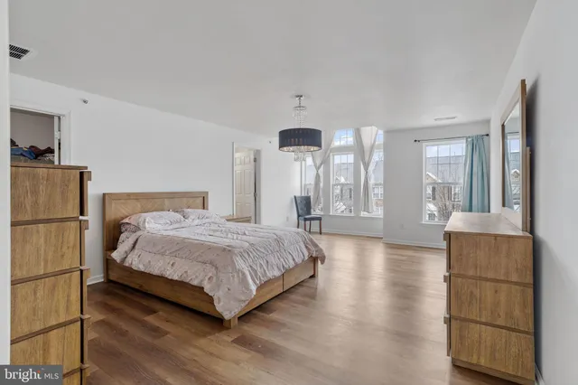 a large bedroom with a bed and wooden floor