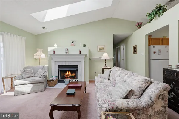 a living room with furniture a large window and a fireplace