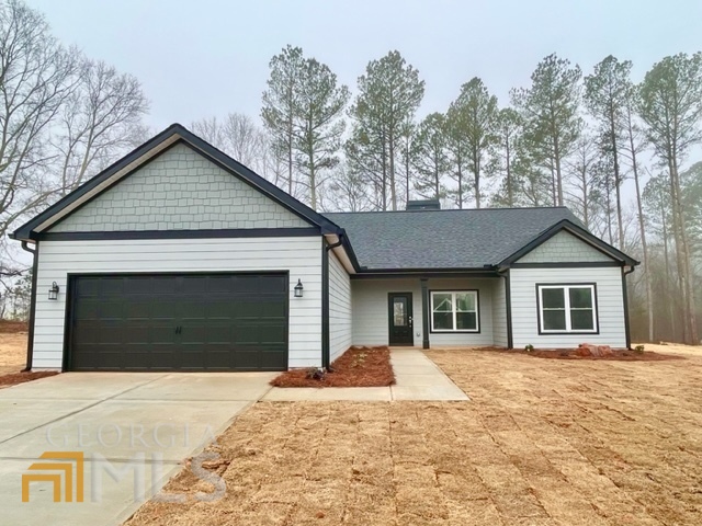 a front view of a house with yard and trees