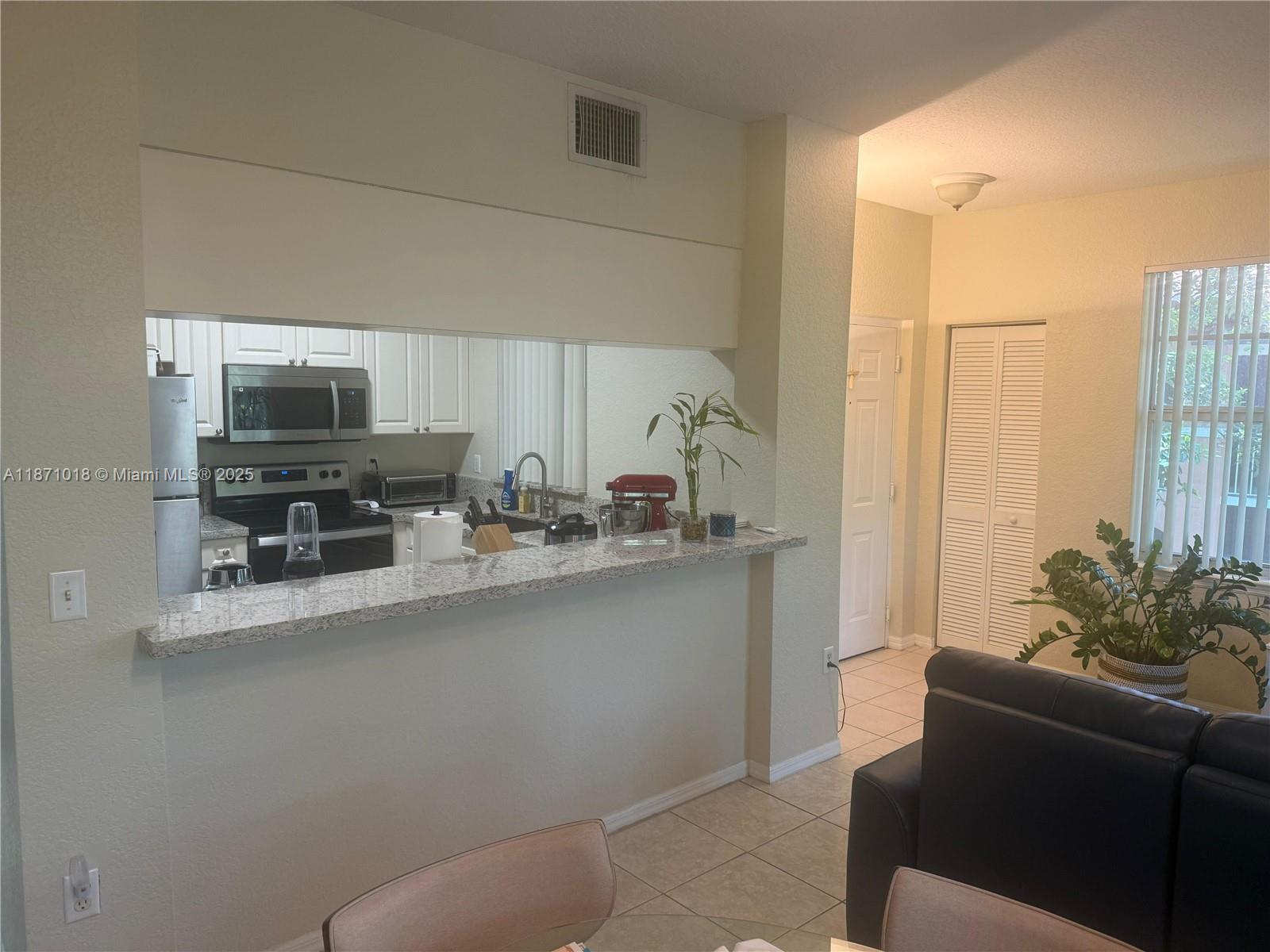 6876 West Sample Road, Unit 6876 Coral Springs, FL 33067 - Photo 11 of 27 a living room with furniture and a flat screen tv