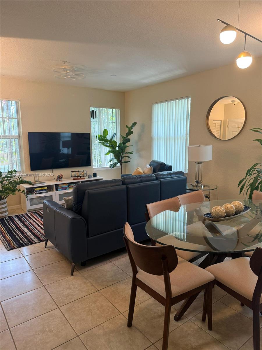 6876 West Sample Road, Unit 6876 Coral Springs, FL 33067 - Photo 14 of 27 a living room with furniture and a flat screen tv