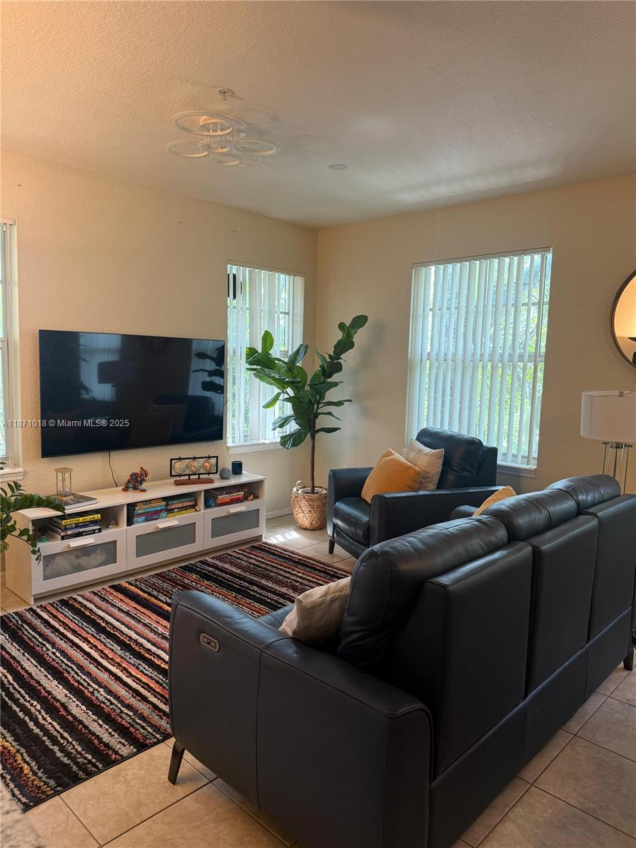 6876 West Sample Road, Unit 6876 Coral Springs, FL 33067 - Photo 15 of 27 a living room with furniture and a flat screen tv