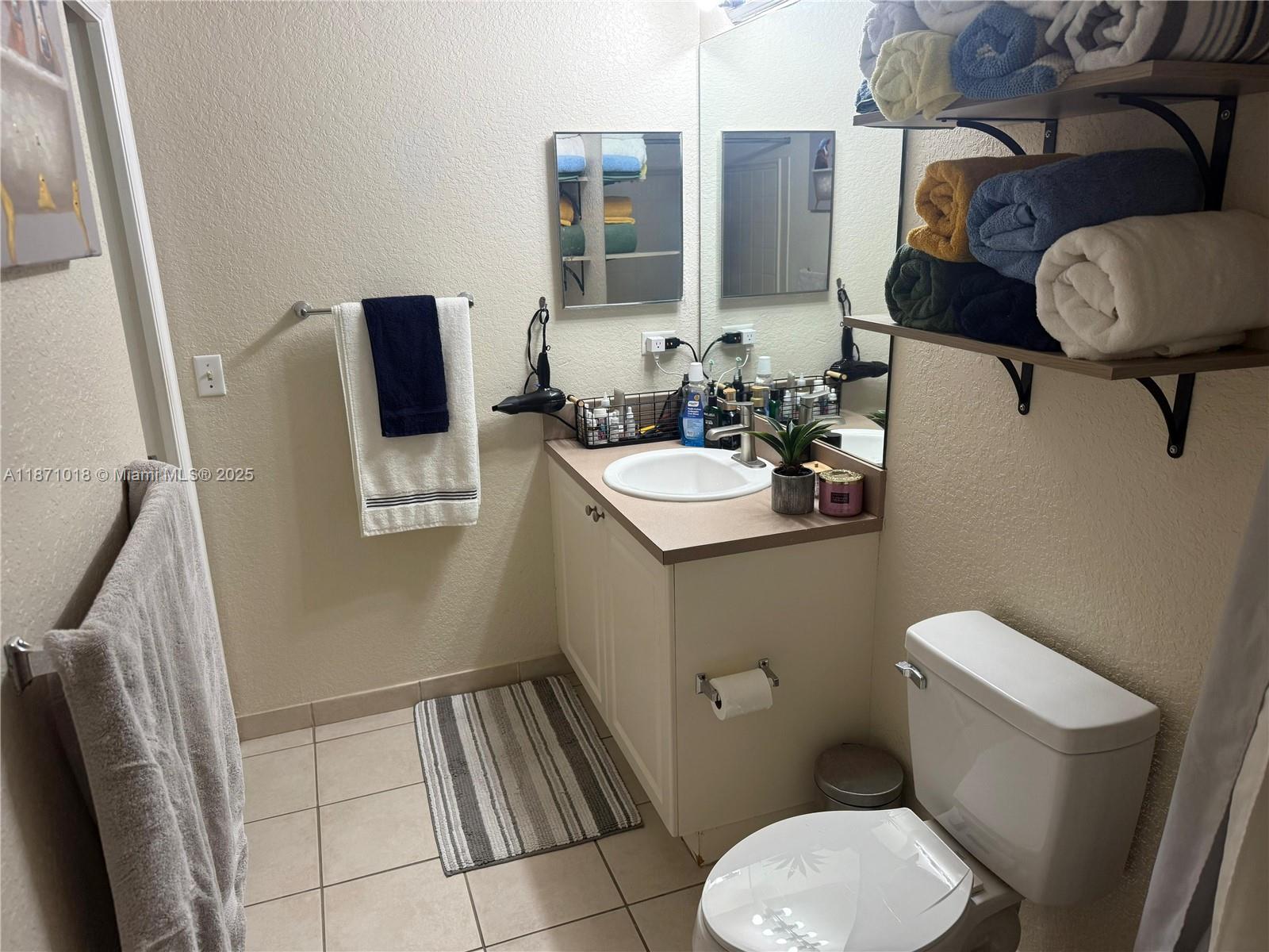 6876 West Sample Road, Unit 6876 Coral Springs, FL 33067 - Photo 18 of 27 a bathroom with a toilet sink and mirror