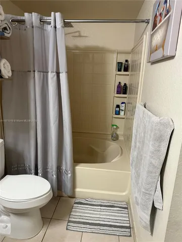a bathroom with a sink a toilet and shower curtain