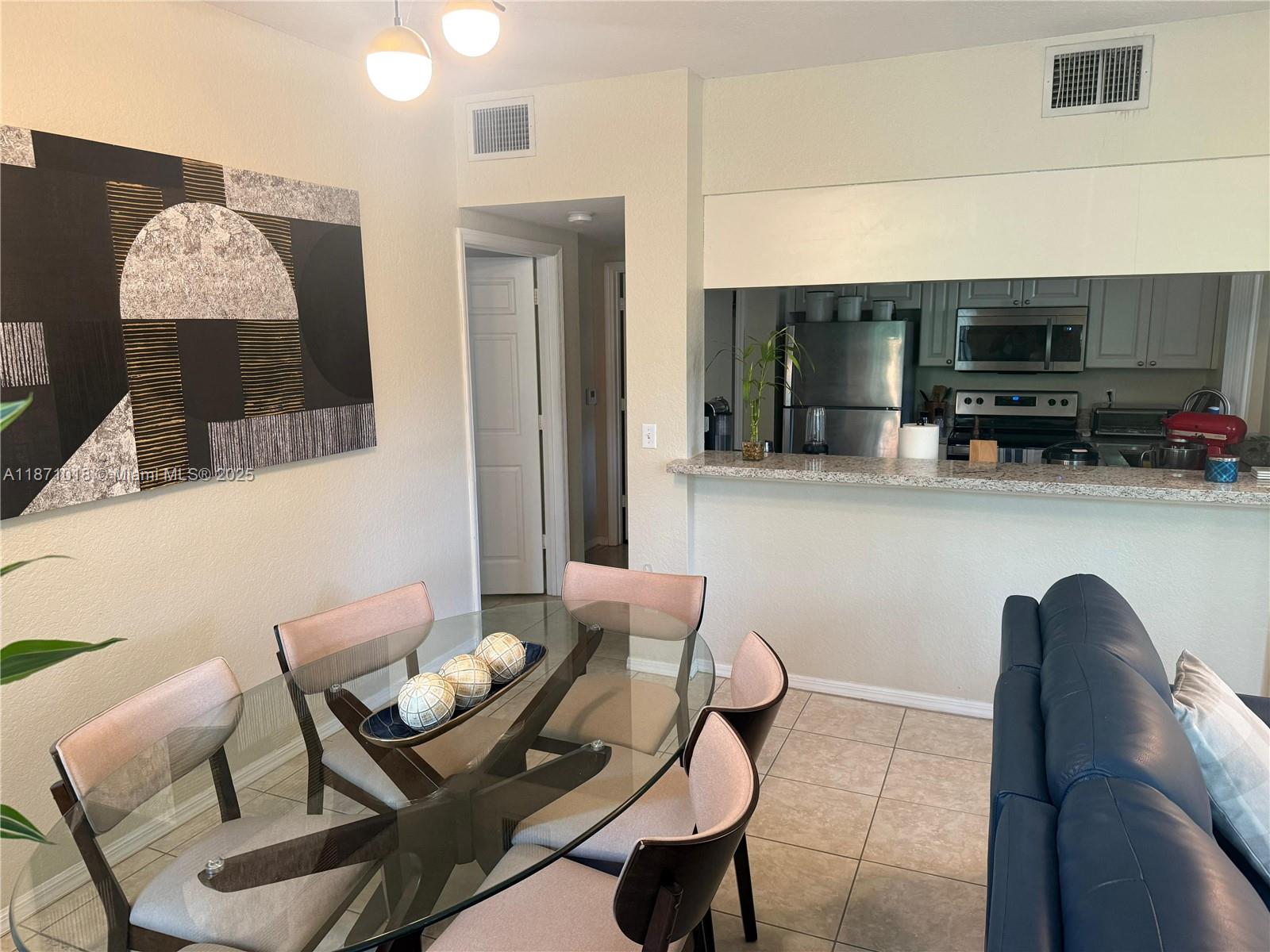 6876 West Sample Road, Unit 6876 Coral Springs, FL 33067 - Photo 2 of 27 a living room with furniture a flat screen tv and kitchen view