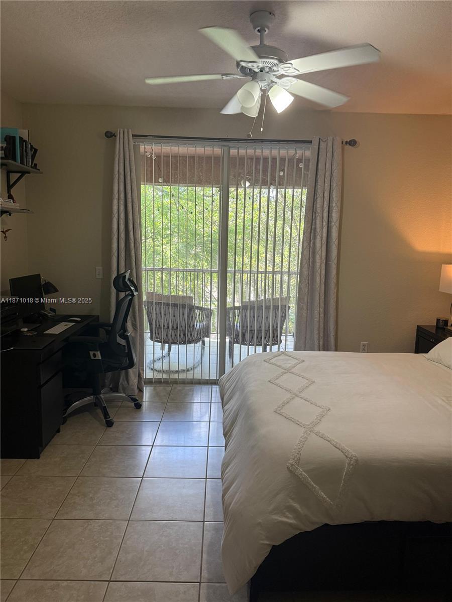 6876 West Sample Road, Unit 6876 Coral Springs, FL 33067 - Photo 23 of 27 a bedroom with a bed and a ceiling fan