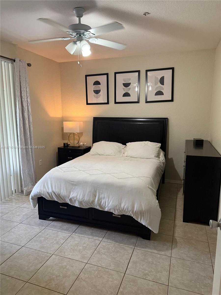 6876 West Sample Road, Unit 6876 Coral Springs, FL 33067 - Photo 24 of 27 a bedroom with a bed and a chandelier