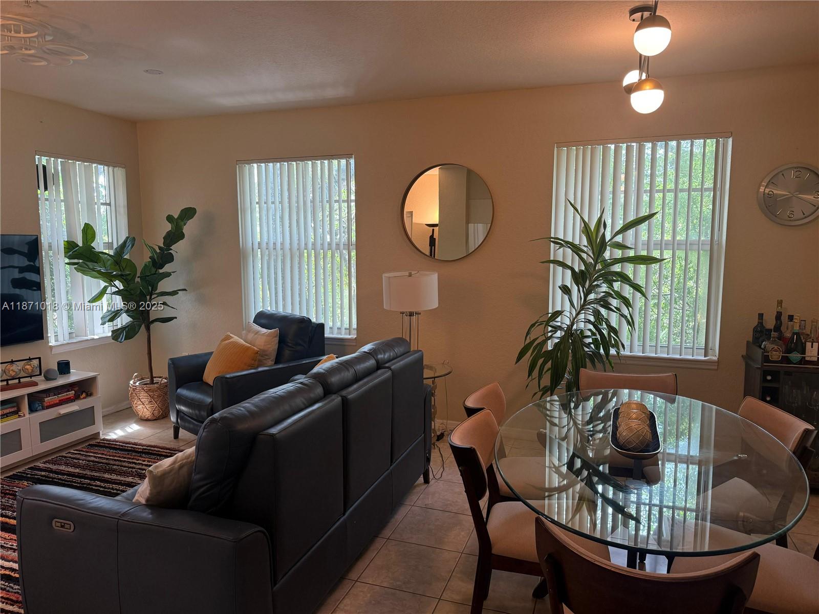 6876 West Sample Road, Unit 6876 Coral Springs, FL 33067 - Photo 5 of 27 a living room with furniture a potted plant and a large window