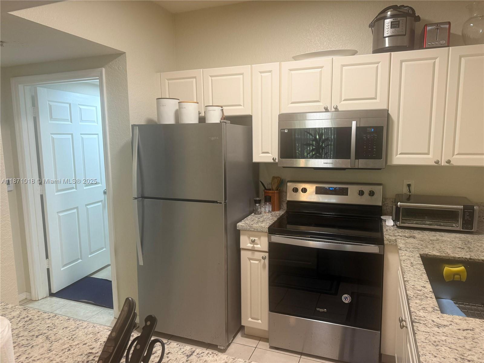 6876 West Sample Road, Unit 6876 Coral Springs, FL 33067 - Photo 6 of 27 a kitchen with a refrigerator stove and microwave