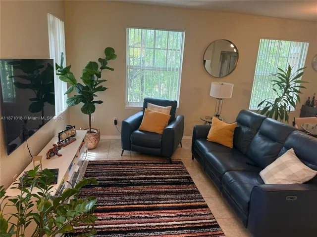 a living room with furniture and a potted plant