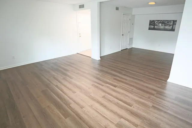 a view of an empty room with wooden floor