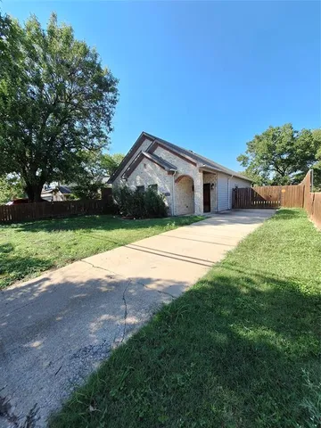 a front view of a house with yard and green space