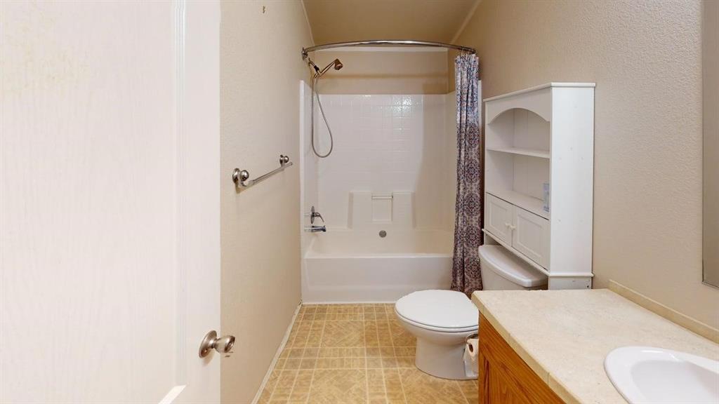 1301 East Pontotoc Street Mason, TX 76856 - Photo 24 of 26 a bathroom with a granite countertop toilet sink and shower