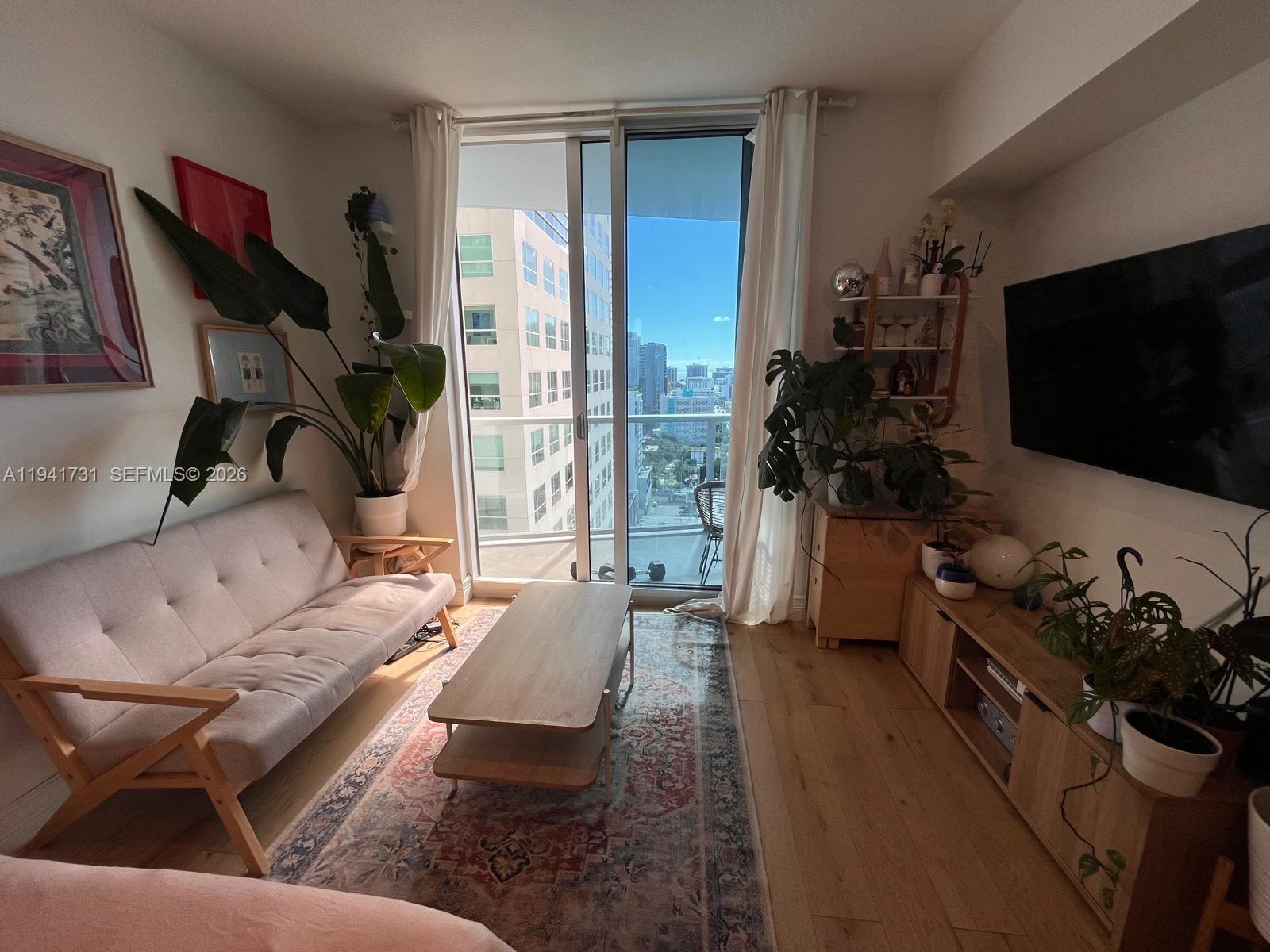 185 Southwest 7th Street, Unit 2006 Miami, FL 33130 - Photo 2 of 14 a living room with furniture and a flat screen tv