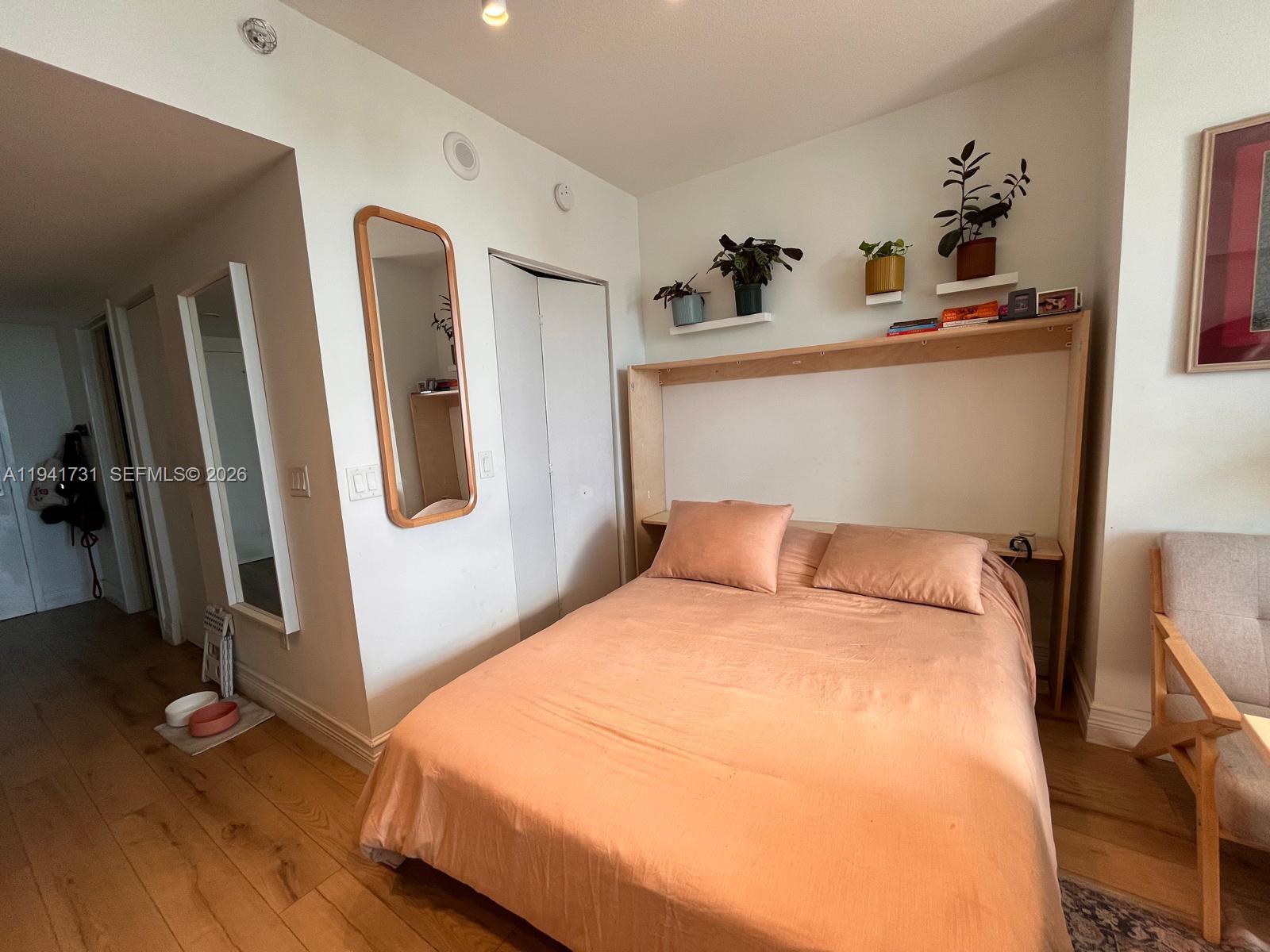 185 Southwest 7th Street, Unit 2006 Miami, FL 33130 - Photo 3 of 14 a bedroom with bed and wooden floor
